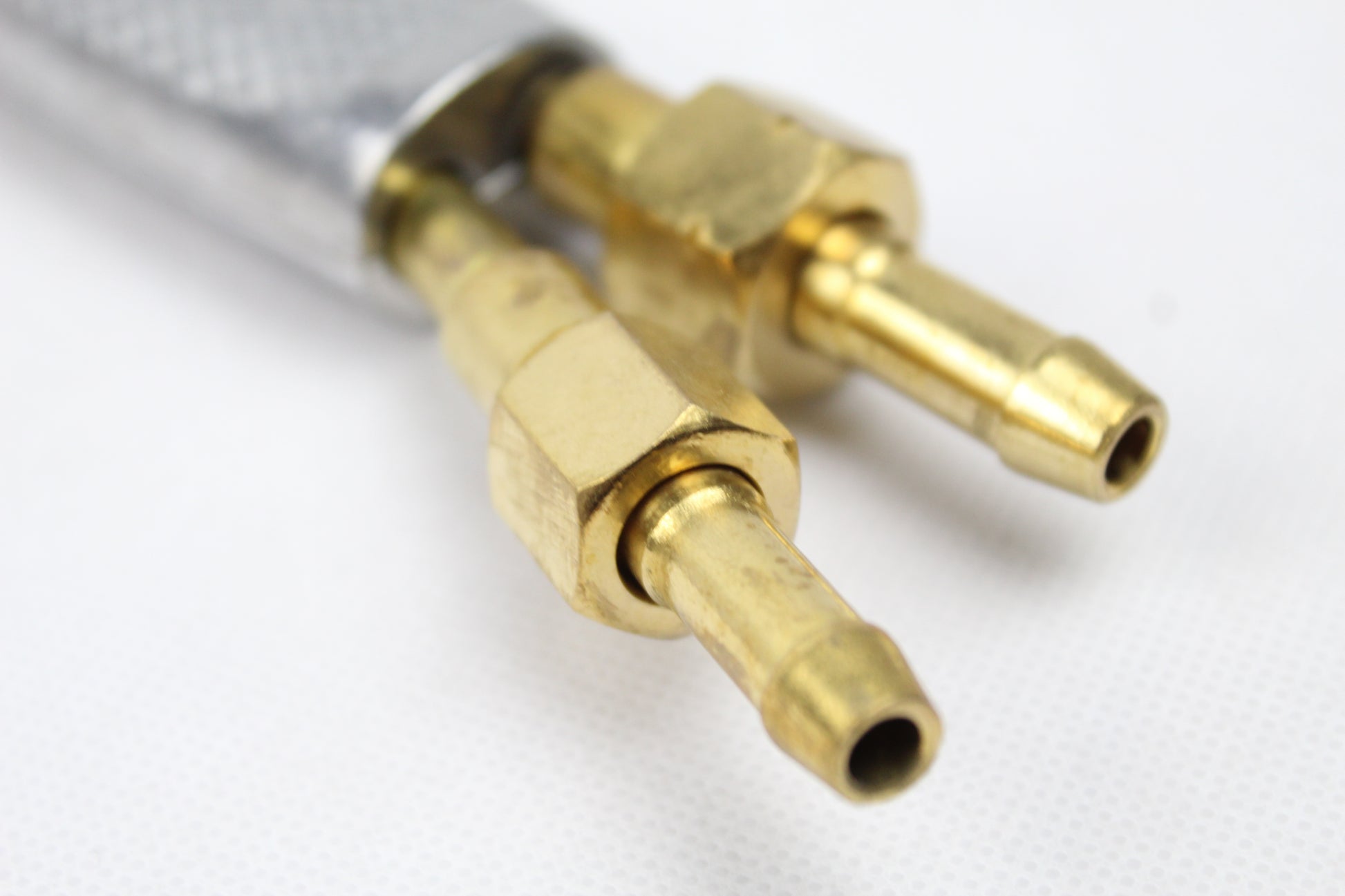 Krupni plan dva mesingana konektora na beloj pozadini
