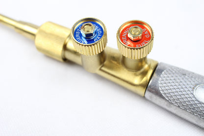 Mesingani aparat za zavarivanje sa ventilima za kiseonik i acetilen na beloj pozadini